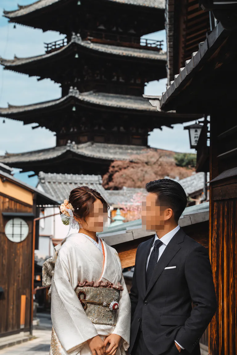 일본 거리에서 정장과 전통 의상을 입고 함께 서 있는 두 사람
