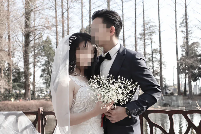 야외에서 꽃다발을 함께 들고 있는 웨딩 복장의 두 사람